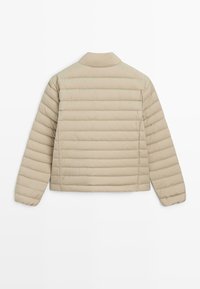 Giacca trapuntata beige chiaro con colletto, caratterizzata da cuciture orizzontali, maniche lunghe e un taglio dritto all'orlo.