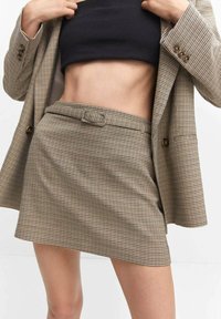 Mini-jupe marron à motif pied-de-poule avec un blazer assorti, comprenant une taille ceinturée et une texture de tissu lisse.