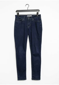 Mörkblå smala jeans i denim, med fem fickor, dragkedja och bälteshål i midjan. Slät textur och åtsittande design.