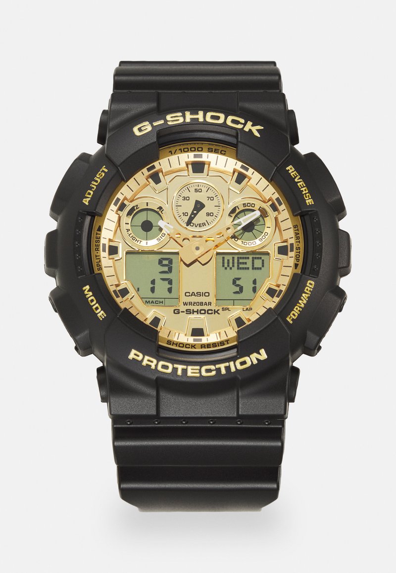 Reloj digital-analógico negro con acentos dorados, gran esfera redonda, correa de goma, tres sub-esferas, y la marca "G-SHOCK". Impermeable y resistente a los golpes.