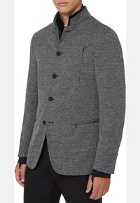 Gray textured jacket featuring a high collar, four front buttons, and a zippered pocket on the chest. Designed for a fitted look.