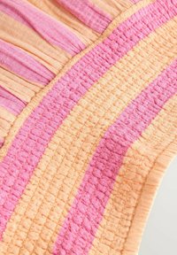 Textil vízszintes csíkokkal lágy barack és rózsaszín árnyalatokban, textúrált szövött mintával. Az élek simák, ráncolt szövet részletekkel.