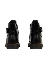 Botines negros de tobillo con cuero texturizado, punta redonda, correa decorativa y detalle de hebilla. Suela resistente con un ligero tacón.