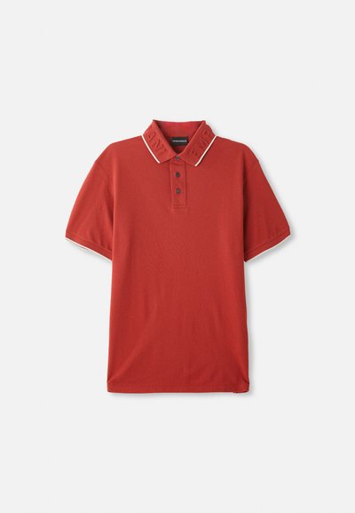 Sarkans polo krekls ar teksturētu apkakli, logotipu, trīs pogu plati, īsām piedurknēm un kontrastējošu maliņu apkaklē.