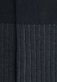 Tessuto in maglia di colore blu navy scuro con costine a contrasto dalla texture. Presenta una sezione superiore liscia e una sezione inferiore a strisce verticali.