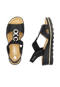 Sandalo in pelle nera con cinturini regolabili, hardware decorativo in argento, soletta imbottita, intersuola in contrasto color kaki e suola testurizzata.