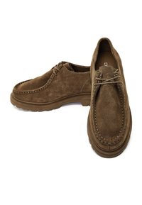 Paar braune Wildleder-Schnürschuhe mit dicken Gummisohlen, kontrastierende Nähte, ein Schuh schräg gestellt, um Ober- und Seitenansichten zu zeigen.