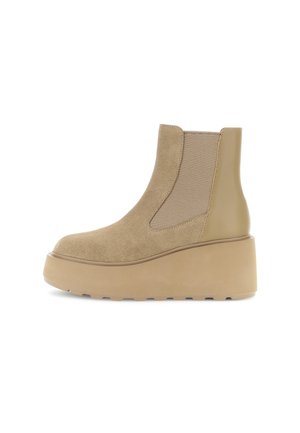 Stivale alla caviglia beige realizzato in suede ed elastico, con una suola a piattaforma robusta e un accento liscio e lucido sul retro.