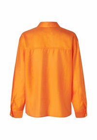 Camicia arancione con bottoni, maniche lunghe, colletto e una texture liscia. Presenta uno yoke e polsini con bottoni per una vestibilità regolabile.