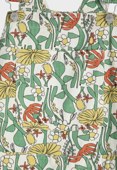 Tissu à imprimé floral avec des tiges vertes, des fleurs jaunes, blanches et orange, doté d'une poche centrale et de deux boutons en métal sur les bretelles.