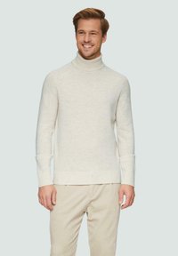 Romige coltrui van zachte textuur, met geribde boorden en zoom, gecombineerd met lichtbeige corduroy broeken. Eenvoudig, gestroomlijnd ontwerp.