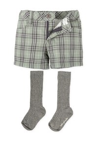 Pantalones cortos de cuadros verdes con botón y cremallera, combinados con calcetines gris de canalé hasta la rodilla. El material parece suave y flexible.