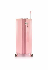 Valigia rigida di colore rosa pastello, con superficie texturizzata, doppie cerniere, manico retrattile e quattro ruote multidirezionali.
