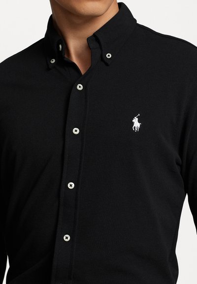 Zwarte button-up shirt van katoen, met een klassieke kraag, gestructureerde stof en een klein wit geborduurd logo op de borst.