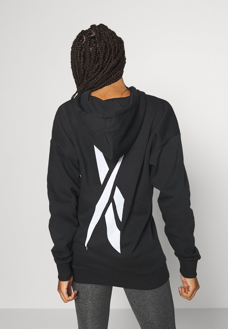 Czarna bluza z kapturem z dużym białym logo na plecach. Posiada luźny krój i ściągacze przy rękawach, wykonana z miękkiego, teksturowanego materiału.