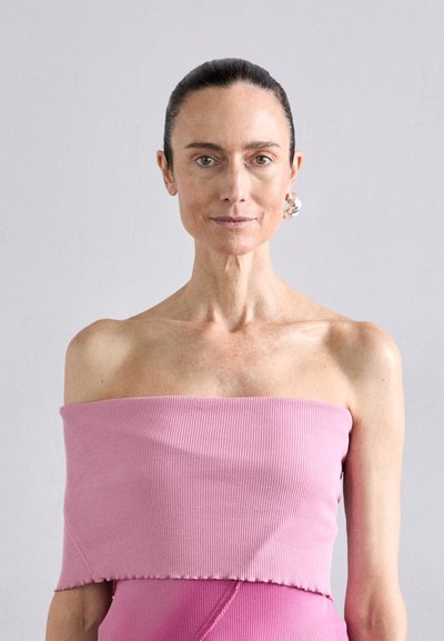 Rosa schulterfreies Oberteil mit geripptem Material, das ein enges Design und einen raw edge Saum aufweist. Der Stoff scheint weich und dehnbar zu sein.