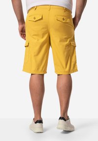 Žluté cargo šortky se dvěma zadními kapsami a bočními kapsami. Vyrobené z bavlněné látky, s rovný střih a volným střihem.