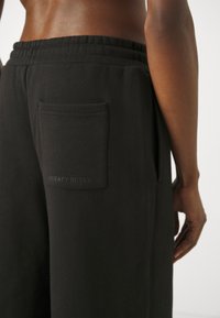 Svarta sweatpants i mjukt material, med elastisk midja och en bakficka med "SWEATY BETTY"-logotyp prägling.