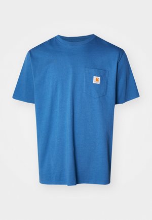 Camiseta de algodón azul con cuello redondo, mangas cortas y un bolsillo en el pecho izquierdo con un parche de logo. Textura suave, diseño casual.