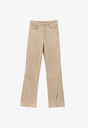 Pantalon beige à coupe droite, fabriqué en tissu doux, avec des fentes à l'ourlet, des poches avant et des boutons en métal en guise d'accents.