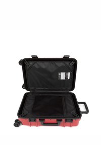 Red hard-shell suitcase with black interior, wheels, and retractable handle. Features mesh pocket and tags inside. Opened for visibility.