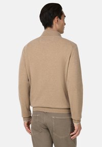 Beige wool sweater with a high collar, ribbed cuffs, and hem. The back features a smooth texture and minimalistic design.