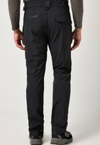 Pantalones de senderismo negros con una textura suave, que cuentan con un bolsillo trasero y una cintura ajustable. Diseñados con costuras flexibles para mayor movilidad.