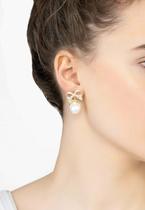 Gold-tone earrings featuring a bow design embellished with clear crystals and a large, lustrous pearl drop.