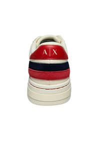 Weiße Sneakers mit einem rot und navy gestreiften Design an der Ferse, aus Leder und Wildleder, und geprägtem „A|X“-Logo auf der Rückseite.