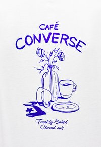 Εικονογράφηση σκηνής καφετέριας με ένα βάζο με λουλούδια, φλιτζάνι καφέ, πιατάκι και πιάτο σε λευκό φόντ ο, με μπλε περιγράμματα και κείμενο.