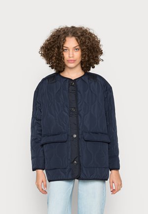 Giacca trapuntata navy con scollo rotondo, chiusura a bottoni, due tasche frontali e motivo testurizzato. Adatta a diverse condizioni atmosferiche.