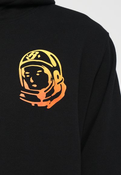 Sort sweatshirt med et stiliseret astronautgrafik. Grafikken skifter fra gul til orange og er placeret på brystområdet.