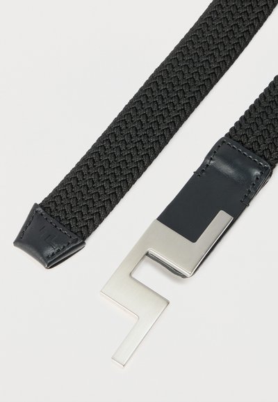 Μαύρη υφασμάτινη ζώνη με δερμάτινη άκρη και μοναδική γωνιακή ασημένια μεταλλική αγκράφα σε λευκό φόντο.