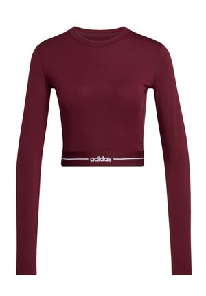 Vínově červený crop top s dlouhým rukávem z hladké látky, s bílým páskem s logem Adidas a kulatým výstřihem.