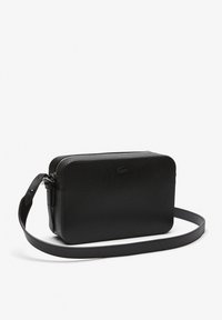 Borsa a tracolla nera, textured, di forma rettangolare, con chiusura a zip e una lunga tracolla. Presenta un logo sottile sul davanti.