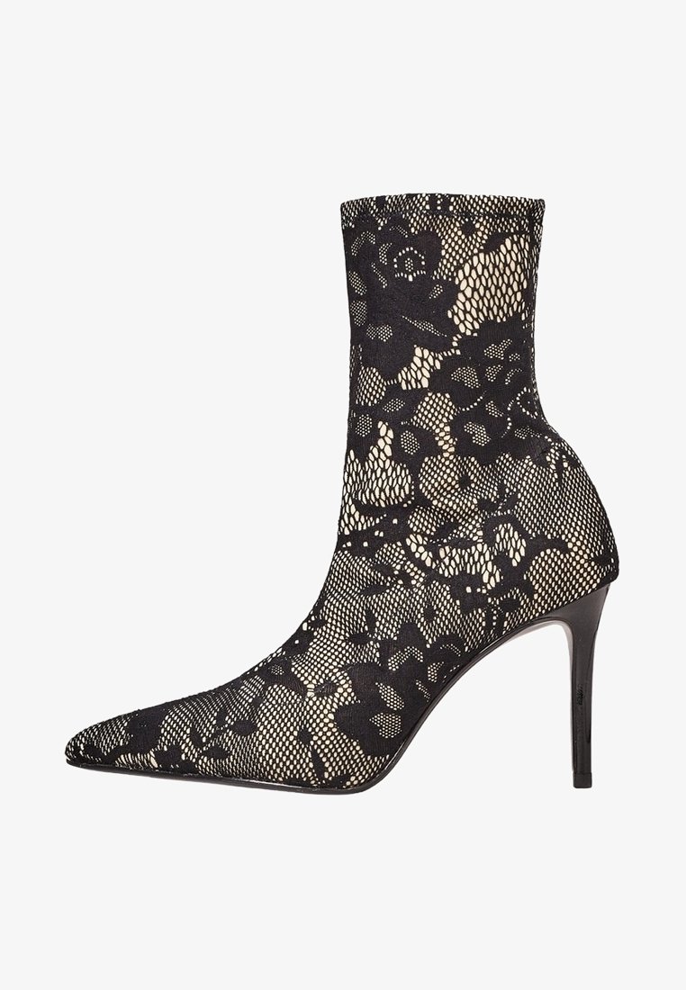 Bottine noire à talon haut recouverte d’une dentelle florale délicate, avec un bout pointu et un talon aiguille fin.