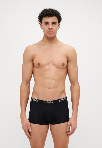 Svarte stretch bomull boxershorts med elastisk strikk med merke. Strikken har vekslende svart og hvit tekst.