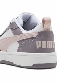 Hvide og grå sneakers med pink accenter, der har en glat læderoverdel, polstret krave og branding på hælen. Designet til komfort.