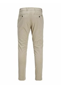 Béžové kalhoty s hladkou texturou, vybavené dvěma zadními kapsami se zapínáním na černé knoflíky a upraveným slim fit designem.