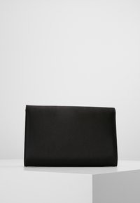 Pochette noire en tissu mat et lisse. Forme rectangulaire avec bords nets, sans ferrures visibles ni motifs. Design simple.