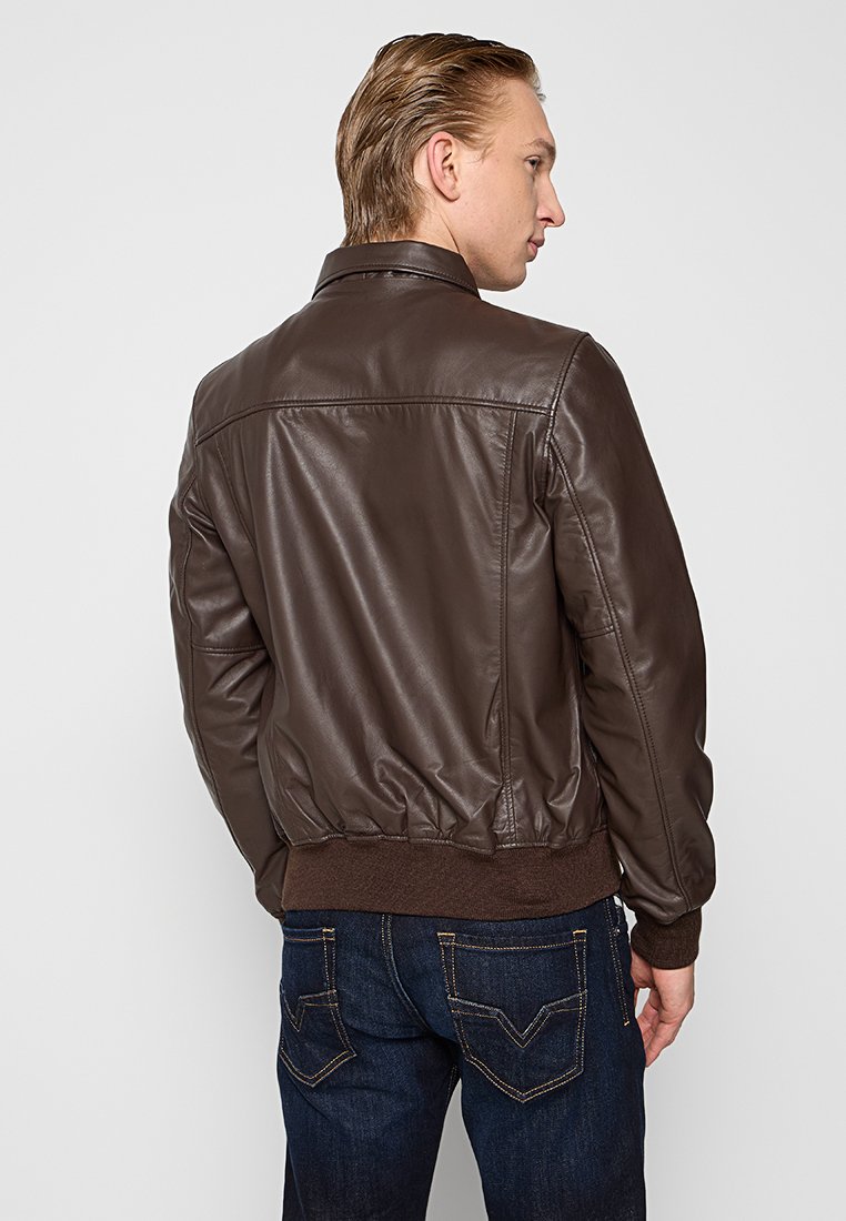 Veste bomber en cuir brun avec des poignets et une ceinture côtelés, présentant un extérieur lisse et des coutures, vue de dos.