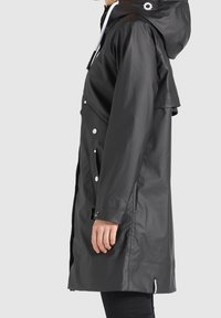 Černý voděodolný plášť s kapucí, druky, bočními kapsami a hladkým povrchem. Vybaven bílými stahovacími šňůrkami a stylovým designem.
