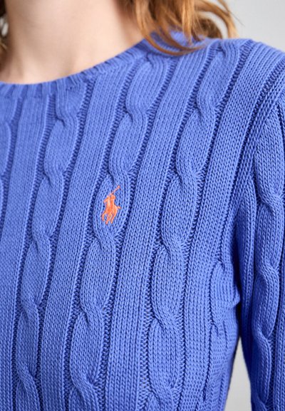 Heledad soe kerge sinises toonis, millel on soonikstruktuur ja väike oranž logo rinnal. Ümar kaelus ja pikad varrukad.