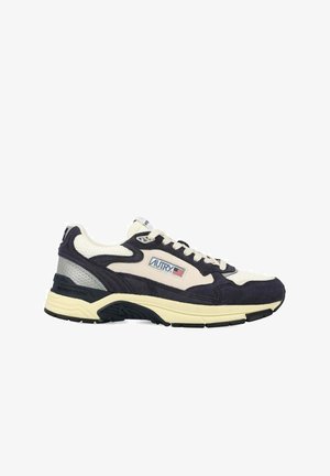 Sneaker con una combinazione di pelle scamosciata blu navy scuro e tomaia in mesh color crema, con una suola spessa e accenti di pannelli argentati. Logo AUTRY in evidenza.