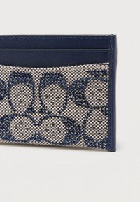 Θήκη καρτών από δερματίνη σε ναυτικό μπλε χρώμα, διακοσμημένη με υφαντό μπεζ ύφασμα με γαλάζιο διαμάντι και μικρές μεταλλικές λεπτομέρειες, με πολλαπλές θήκες για κάρτες.