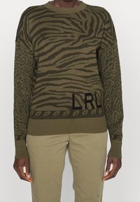 Maglione verde oliva con un motivo a strisce di tigre testurizzato sul davanti e stampa leopardata sulle maniche, con il logo "LRL" sull'orlo.