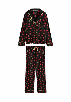 Black pajama set featuring a button-up top and loose pants, adorned with red and gold lip patterns, accented with gold piping and a drawstring waist.