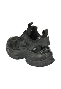 Baskets noires avec une semelle épaisse, une tige en mesh et des accents en caoutchouc. Dotées d'une languette de tirage et de détails de logo en relief sur le côté et à l'arrière.