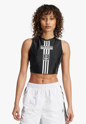 Top corto nero con logo Adidas bianco e tre strisce verticali sul davanti. Tessuto morbido con un design aderente.