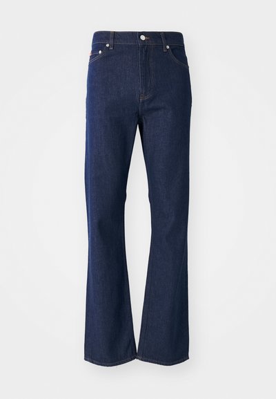 Jeans acampanados de color azul oscuro fabricados en denim. Presentan cinco bolsillos, un cierre frontal con cremallera y un botón metálico. Acentos de costura clásica.